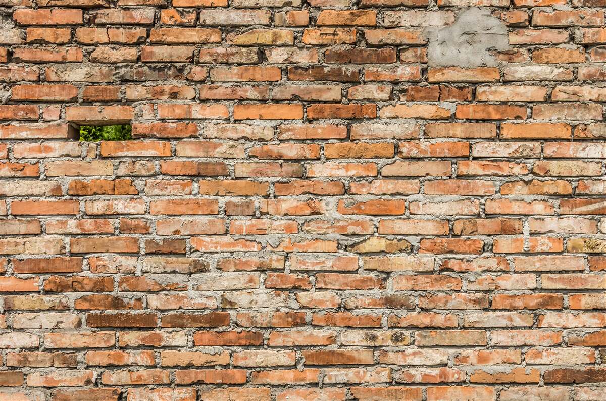 Fototapet Un zid cu cărămizi căzute care și-au pierdut prospețimea