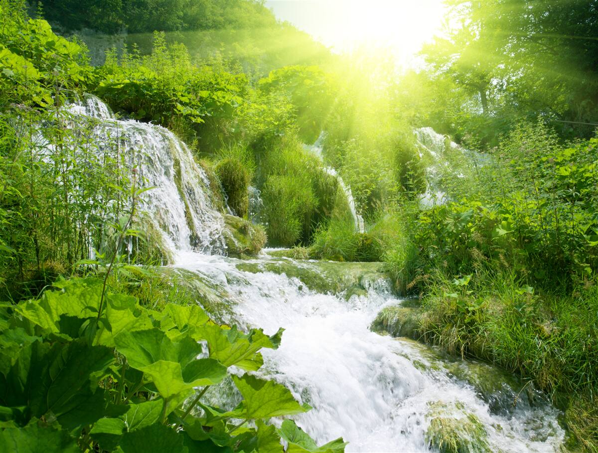 Fototapet un soare orbitor luminează o cascadă spumoasă